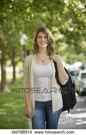 Caucasian student carrying backpack on sidewalk View Large Photo Image Picture - Caucasian student carrying backpack on sidewalk. Fotosearch