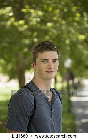 Stock Photo - Caucasian student smiling on sidewalk. Fotosearch
