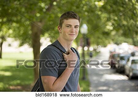 Stock Photo - Caucasian student smiling on sidewalk. Fotosearch
