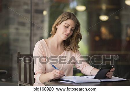 Stock Image - Caucasian student studying at table. Fotosearch