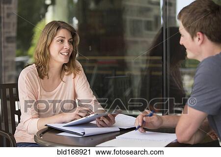 Stock Image - Caucasian students studying at table. Fotosearch