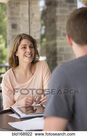 Stock Image - Caucasian students studying at table. Fotosearch
