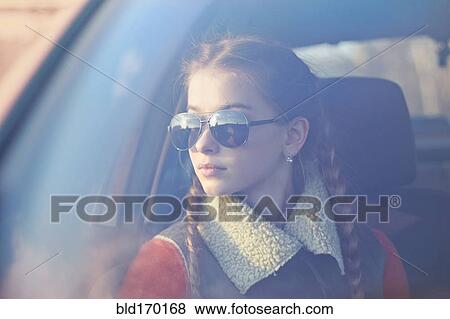 Stock Photo - Caucasian teenage girl sitting in car. Fotosearch