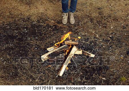 Stock Image - Caucasian teenage girl standing at campfire. Fotosearch