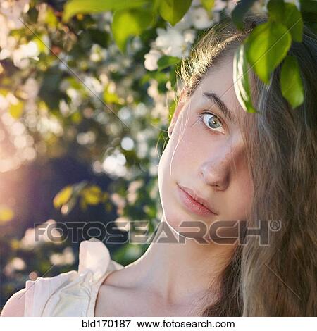 Stock Photo - Caucasian teenage girl standing under tree. Fotosearch