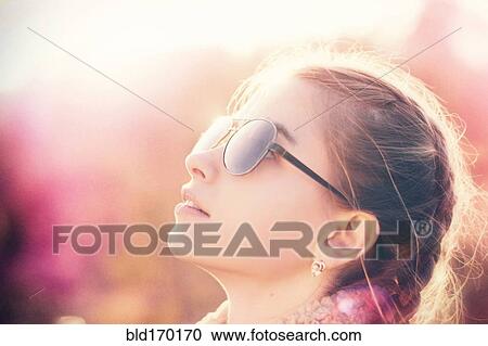 Stock Image - Caucasian teenage girl wearing sunglasses. Fotosearch