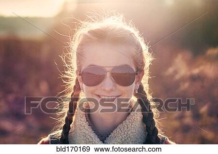 Caucasian teenage girl wearing sunglasses in field View Large Photo Image Stock Photo - Caucasian teenage girl wearing sunglasses in field. Fotosearch