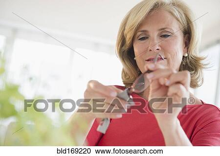 Stock Image - Caucasian woman cleaning eyeglasses. Fotosearch