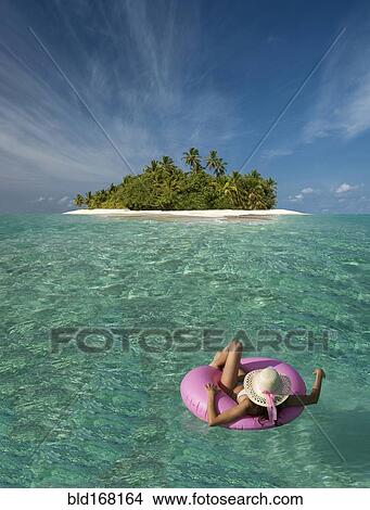 Caucasian woman floating near tropical island View Large Photo Image Picture - Caucasian woman floating near tropical island. Fotosearch