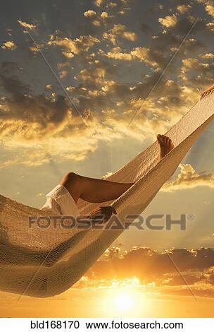 Caucasian woman laying in hammock at sunset View Large Photo Image Stock Image - Caucasian woman laying in hammock at sunset. Fotosearch