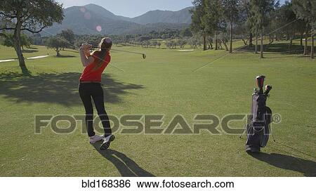 Stock Photograph - Caucasian woman playing golf on course. Fotosearch