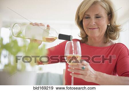 Caucasian woman pouring glass of white wine View Large Photo Image Stock Photo - Caucasian woman pouring glass of white wine. Fotosearch