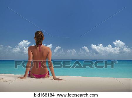 Picture - Caucasian woman relaxing on beach. Fotosearch
