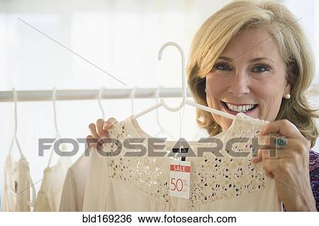 Stock Photograph - Caucasian woman shopping in clothing store. Fotosearch