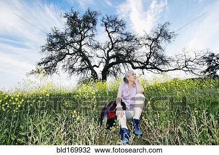 Caucasian woman sitting in tall grass View Large Photo Image Stock Image - Caucasian woman sitting in tall grass. Fotosearch