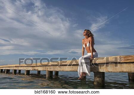 Caucasian woman sitting on wooden dock View Large Photo Image Stock Image - Caucasian woman sitting on wooden dock. Fotosearch