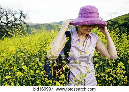 Stock Photo - Caucasian woman standing in tall grass. Fotosearch