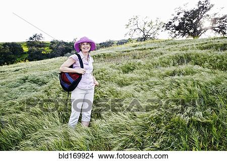 Picture - Caucasian woman standing on hillside. Fotosearch