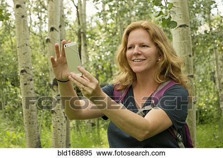 Caucasian woman taking self-portrait in forest View Large Photo Image Stock Photography - Caucasian woman taking self-portrait in forest. Fotosearch