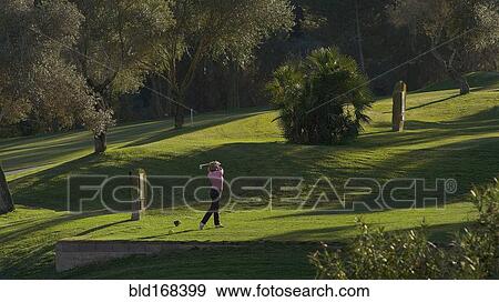 Caucasian woman teeing off on golf course View Large Photo Image Stock Photo - Caucasian woman teeing off on golf course. Fotosearch