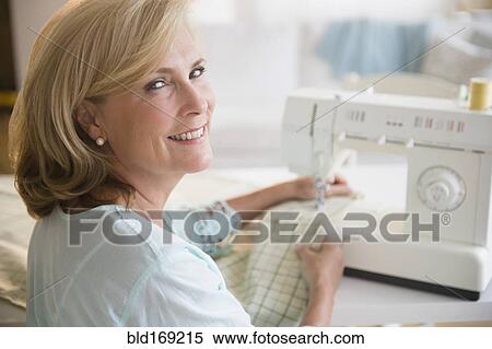 Caucasian woman using sewing machine View Large Photo Image Stock Photography - Caucasian woman using sewing machine. Fotosearch