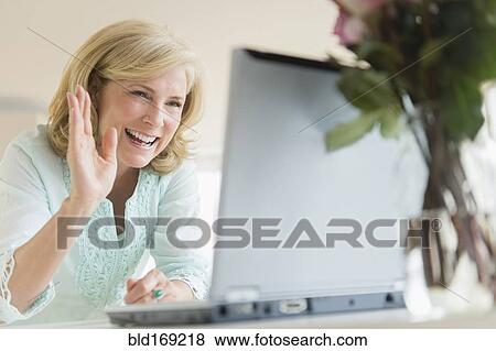 Caucasian woman video chatting on laptop View Large Photo Image Stock Photo - Caucasian woman video chatting on laptop. Fotosearch