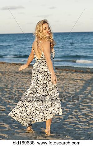 Stock Photo - Caucasian woman walking on beach. Fotosearch