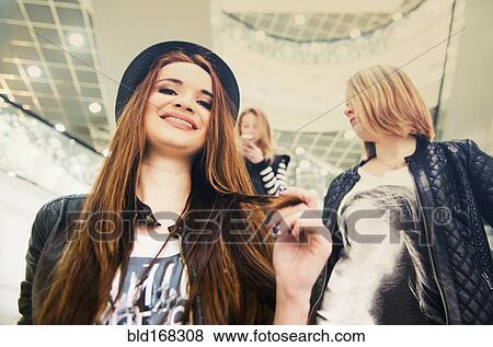 Caucasian women riding escalator in shopping mall View Large Photo Image Stock Photo - Caucasian women riding escalator in shopping mall. Fotosearch