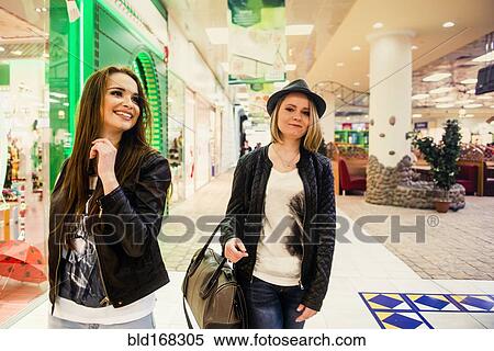 Stock Photography - Caucasian women walking in shopping mall. Fotosearch