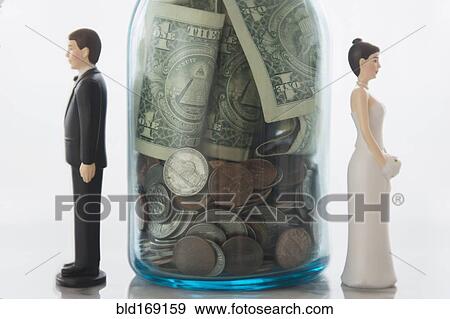 Close up of bride and groom dolls near savings jar View Large Photo Image Stock Photo - Close up of bride and groom dolls near savings jar. Fotosearch