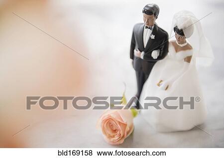 Stock Photo - Close up of bride and groom wedding cake topper. Fotosearch