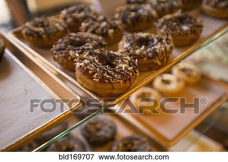 Stock Photo - Close up of donuts for sale in bakery. Fotosearch