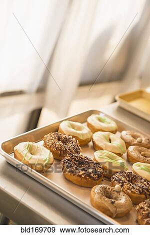 Stock Photo - Close up of donuts for sale in bakery. Fotosearch