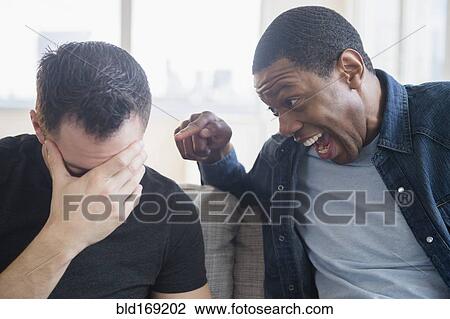 Close up of man teasing friend on sofa View Large Photo Image Stock Image - Close up of man teasing friend on sofa. Fotosearch