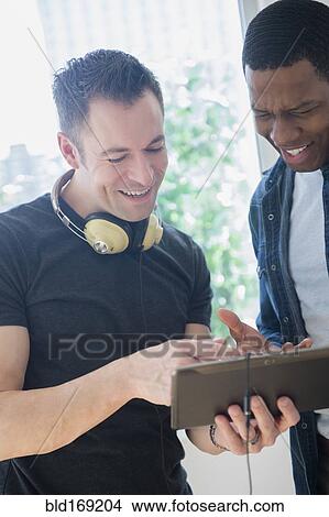 Close up of men sharing digital tablet View Large Photo Image Picture - Close up of men sharing digital tablet. Fotosearch