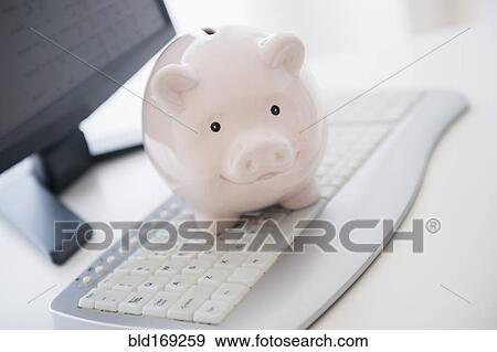 Close up of piggy bank on computer keyboard View Large Photo Image Stock Photo - Close up of piggy bank on computer keyboard. Fotosearch