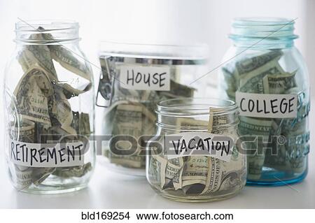 Picture - Close up of savings jars with money. Fotosearch