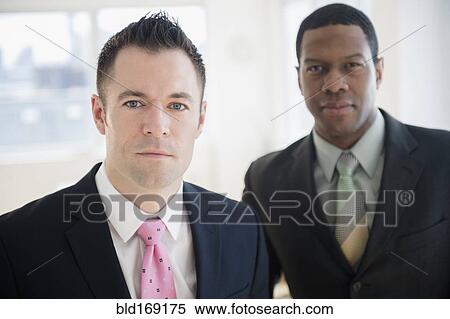 Stock Photography - Close up of serious businessmen in office. Fotosearch