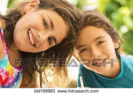Stock Image - Close up of sisters smiling. Fotosearch