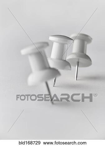 Stock Photo - Close up of three white pushpins. Fotosearch