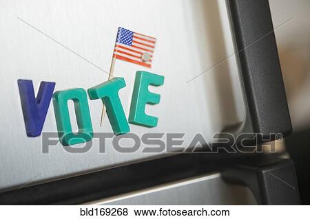 Stock Photo - Close up of vote magnets and American flag on refrigerator. Fotosearch