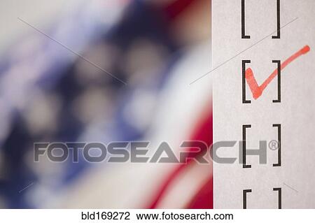 Stock Image - Close up of voting ballot near American flag. Fotosearch