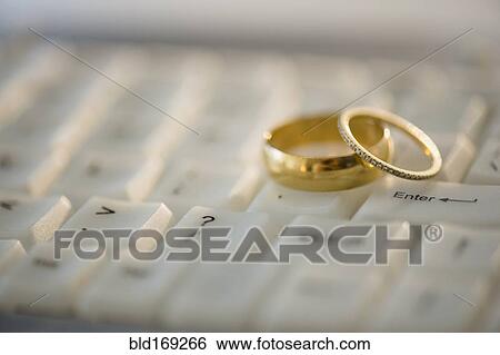Close up of wedding rings on computer keyboard View Large Photo Image Stock Photograph - Close up of wedding rings on computer keyboard. Fotosearch