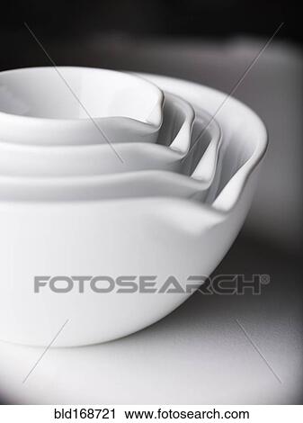 Stock Image - Close up of white nesting bowls with spouts. Fotosearch