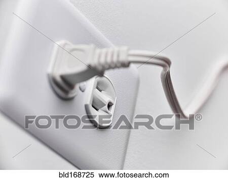 Stock Photography - Close up of white plug in outlet. Fotosearch