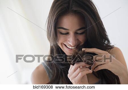 Stock Photo - Close up of woman admiring her hair. Fotosearch