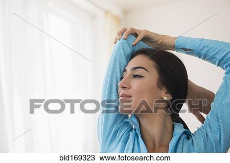 Stock Image - Close up of woman stretching arm. Fotosearch