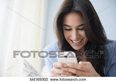 Stock Image - Close up of woman using cell phone. Fotosearch
