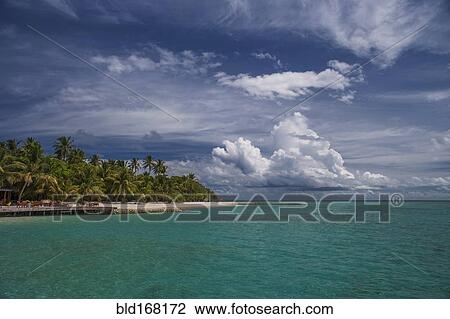Stock Image - Clouds over tropical island. Fotosearch