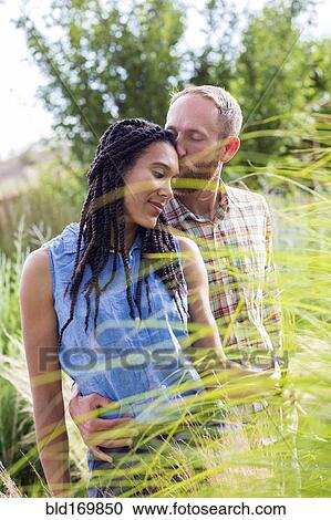 Couple kissing in tall grass in garden View Large Photo Image Stock Image - Couple kissing in tall grass in garden. Fotosearch